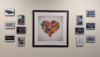 Picture of black and white photographs surrounding a colorful heart made up of hands